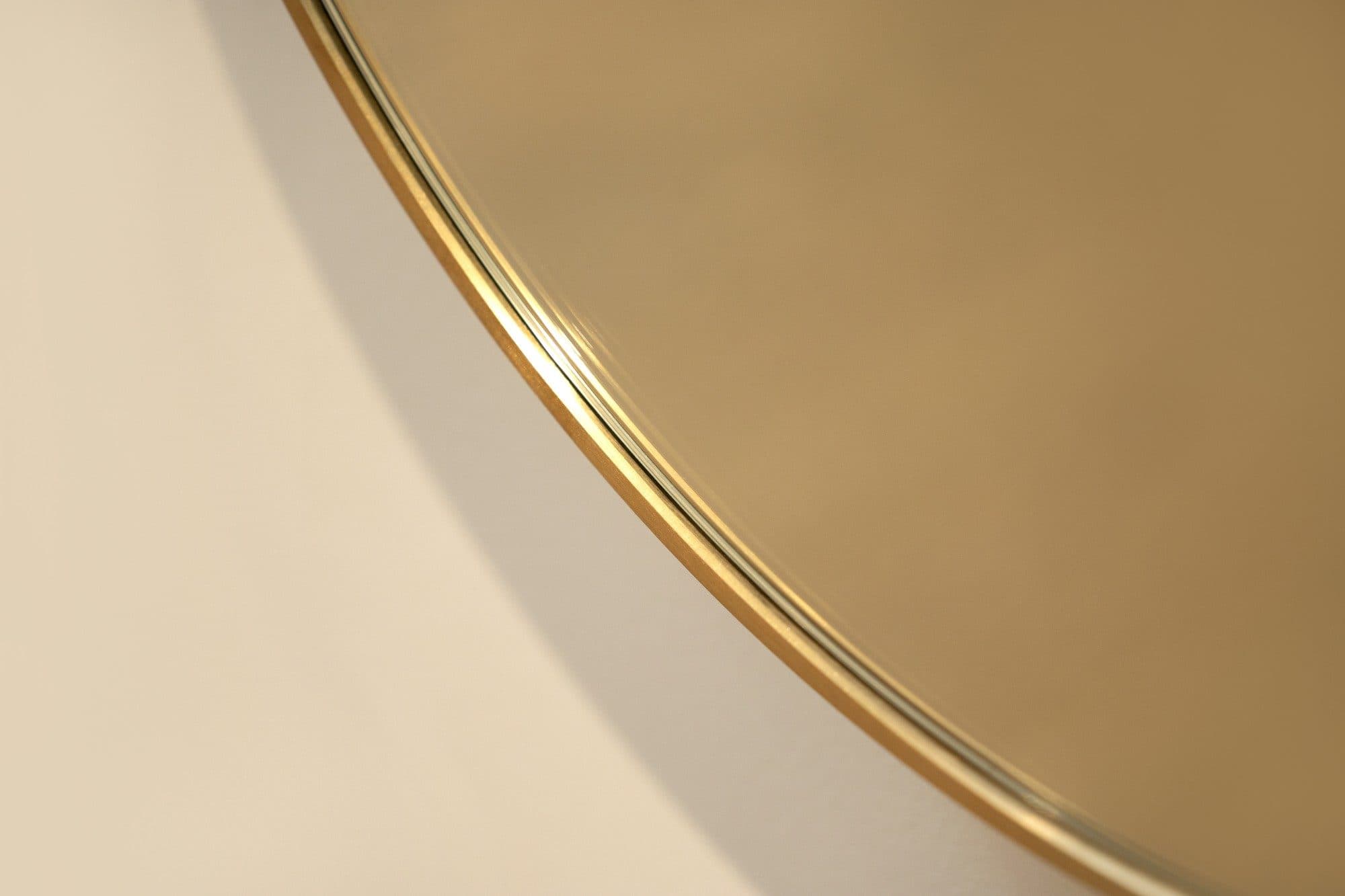 Close detail of a brushed brass mirror frame edge