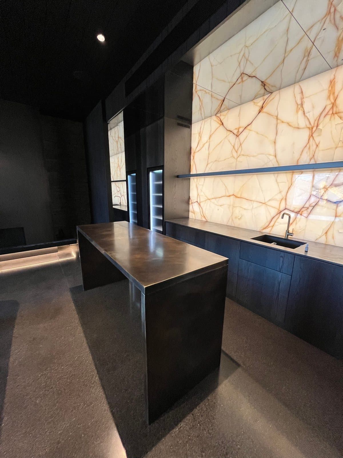 The bronze bar top catching the light from the onyx