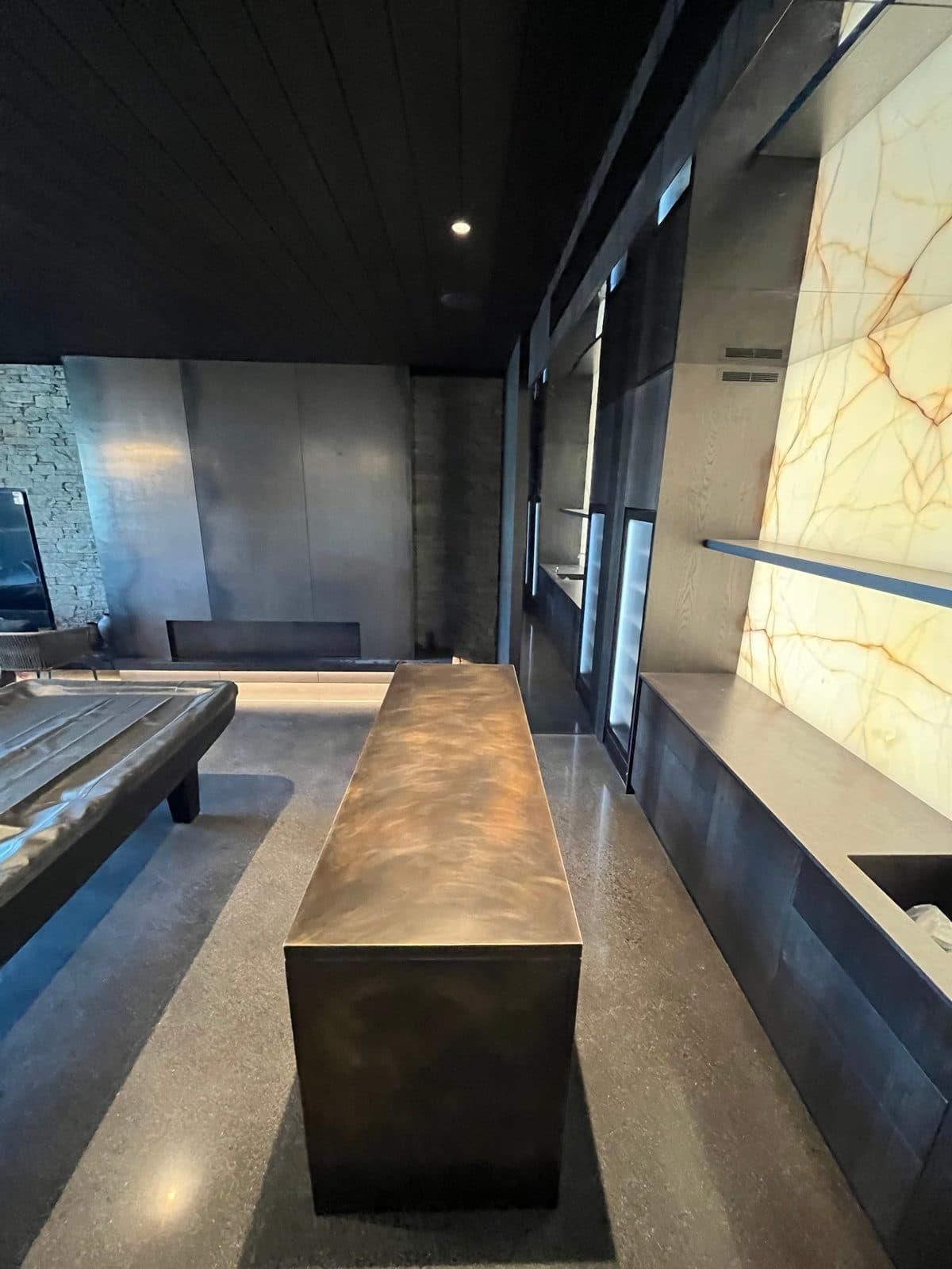 Looking down the bar toward the blackened steel fireplace wall