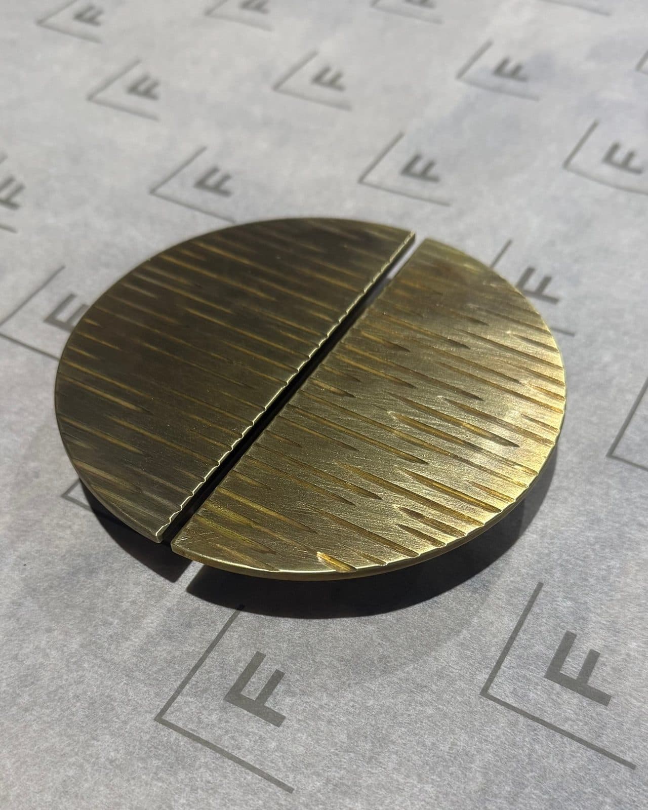 Hand-textured brass half-moon pull in two halves on Fabél tissue paper