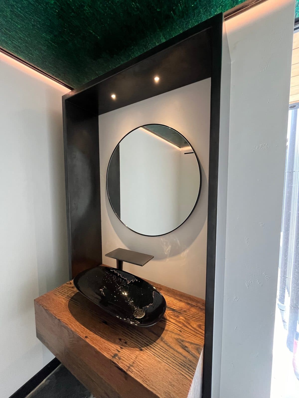 The steel niche seen from the side with a green glass ceiling panel