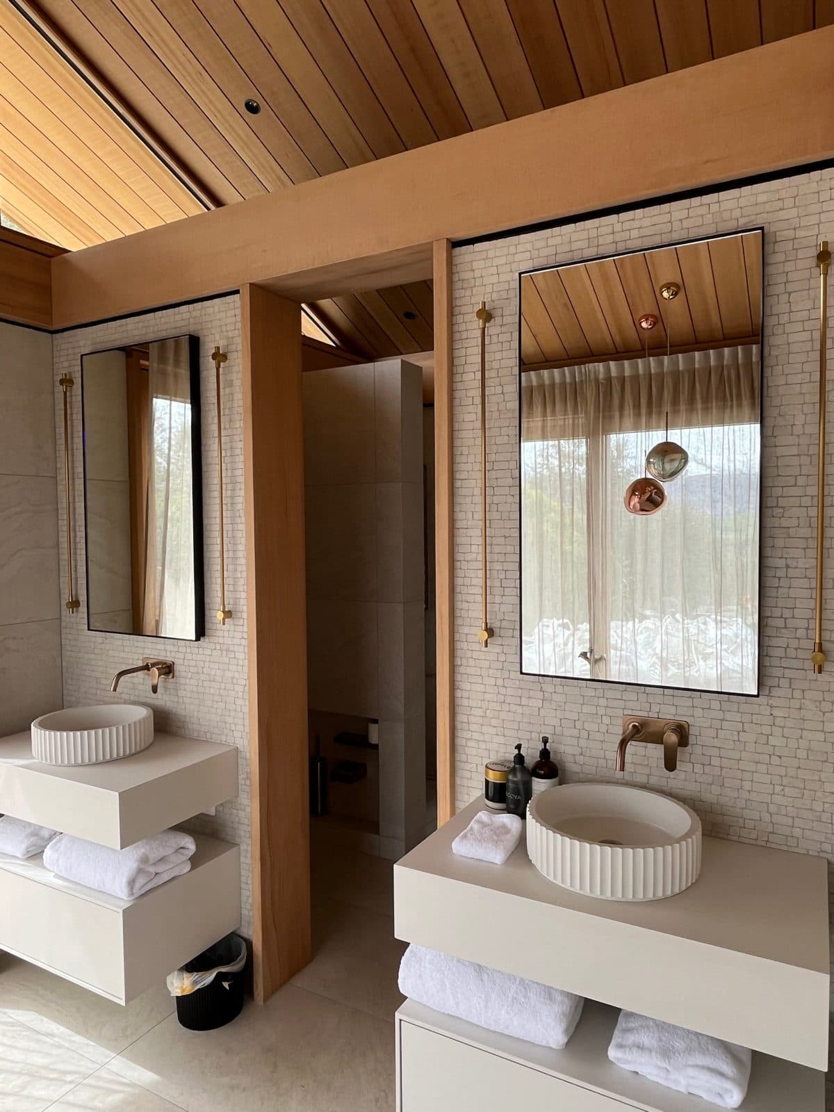 Twin vanities with pendant lights reflected in the mirror